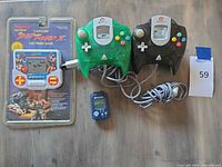 Overall lot showing sealed handheld game, two Dreamcast controllers and Performance module