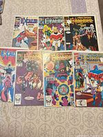 Seven bagged Excalibur comic books laid out on surface
