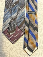 Both neckties laid flat showing front designs and branded linings