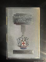 Front view showing embossed text, crest and blank plate