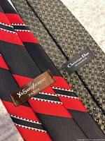 Close-up of both necktie fronts showing patterns and brand labels