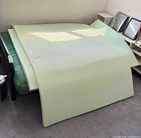 Two light blue-green foam mattress toppers draped over a bed frame