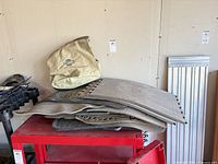Stack of multiple rubber vehicle floor mats on red cart with Nissan canvas bag beside