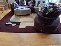 Full view of rectangular burgundy/plum geometric rug under furniture