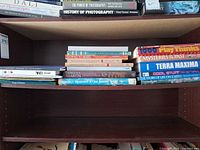 Books stacked on shelf showing titles and formats
