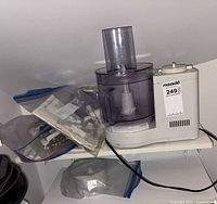 Overall view of Braun food processor assembled on shelf with accessory bag visible