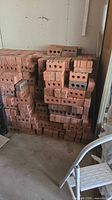 Stacked red/terracotta bricks showing holes and texture