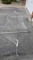 Full view of open-weave cotton rope hammock laid flat with chain attached