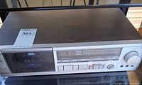 Front and top view of Hitachi D-E57 cassette deck showing controls, cassette bay and cosmetic condition