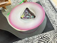 Top view of round frosted white bowl with pink rim and multicolour triangular centre