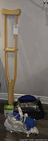 Full lot showing crutches, thermometer box, heating pad in plastic and lumbar cushion