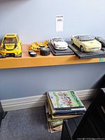 Shelf view with yellow RC shell, loose parts, white Viper and yellow Thunderbird on bases