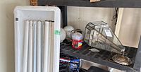 Shelf with fluorescent fixture, hanging lantern, portable lantern, glass globes, wiring