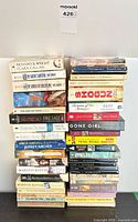 Two vertical stacks totalling about 38 mass market paperback novels by various authors