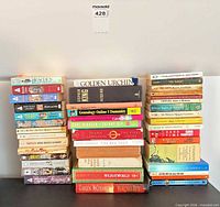 Three vertical stacks of approximately 20 mixed books showing spines and visible wear