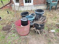 Group of assorted plastic pots on ground