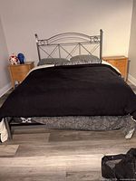 Full view of assembled queen metal bed with bedding