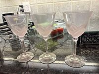 Three of the six pink frosted crystal flutes on counter