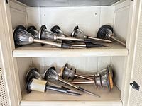 Cabinet shelves holding multiple lantern-style solar stake lights plus one disc light