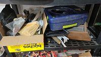 Boxed trowels, brush, scraper, blue plastic tool case and additional tools on shelf