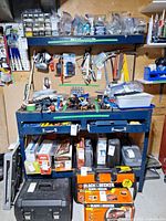 Front view of loaded workbench showing frame, pegboard, drawers, tools and power tool boxes