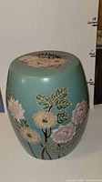 Full view of ceramic garden stool front showing floral design and size reference