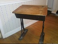 Full view of vintage school desk showing wood top and iron legs