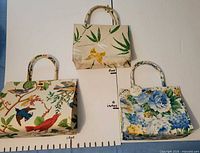 Front view showing all three handbags with size scale