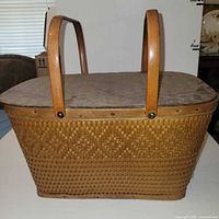 Side view of basket showing weave pattern, handles, lid