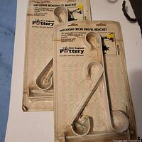 Front view of two packaged wrought iron swivel brackets