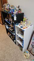 Black and white bookcases side by side filled with figurines