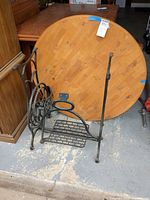 Cast iron treadle base in front of round wood tabletop