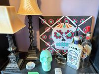Group shot showing skull decor, lamps, souvenir blocks, KAH bottle, additional bottles, paperweight and canvas