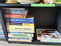 Stacked books showing antiques, real estate exam prep and HGTV magazine