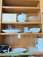 Cabinet view showing bread box, tureen, frosted bowl, platters, dipping bowls, plastic molds