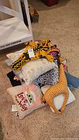 Pile of assorted patterned pillows and plush giraffe