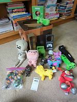 Group shot of all plush toys, figures, cardboard head box and micro figures