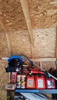 Shelf with two gas cans, boxed compressor, Armor All wipes, jack post box, funnels