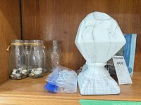 Overall view: glass bottles, resin pedestal, hanger, rings bag on shelf