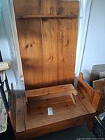 Front view of solid pine storage hall bench with small seat/footstool top resting on main seat and shelf on backboard