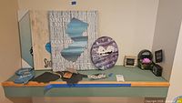 Overall lot on shelf showing major wall signs, clock, flip-flops, small accents
