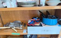 Shelf view showing cookware pieces and utensils together