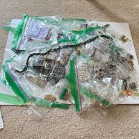 Full lot of bagged costume jewelry spread on board