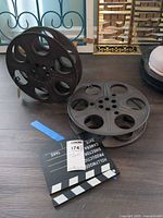 Two decorative film reels and clapperboard arranged on floor