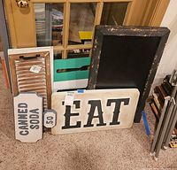 Group showing EAT sign, chalkboard, white shutter accent, brown shutter accent, CANNED SODA sign
