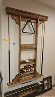 Front view of EastPoint wall rack with cues, balls and triangle