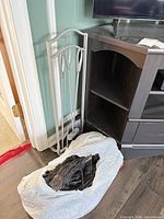 Electric faux log insert inside white bag next to tool set