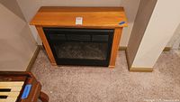 Front view of electric fireplace within wood mantel