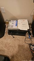 Stacked Mitsubishi and Sony components with manuals on top