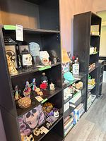 Three black bookcases filled with decor items